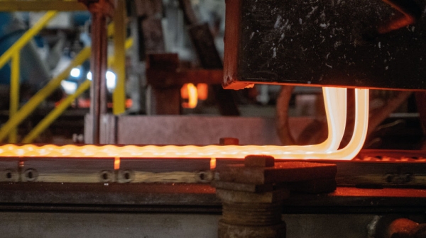 Hot raw glass streams out of a furnace. 